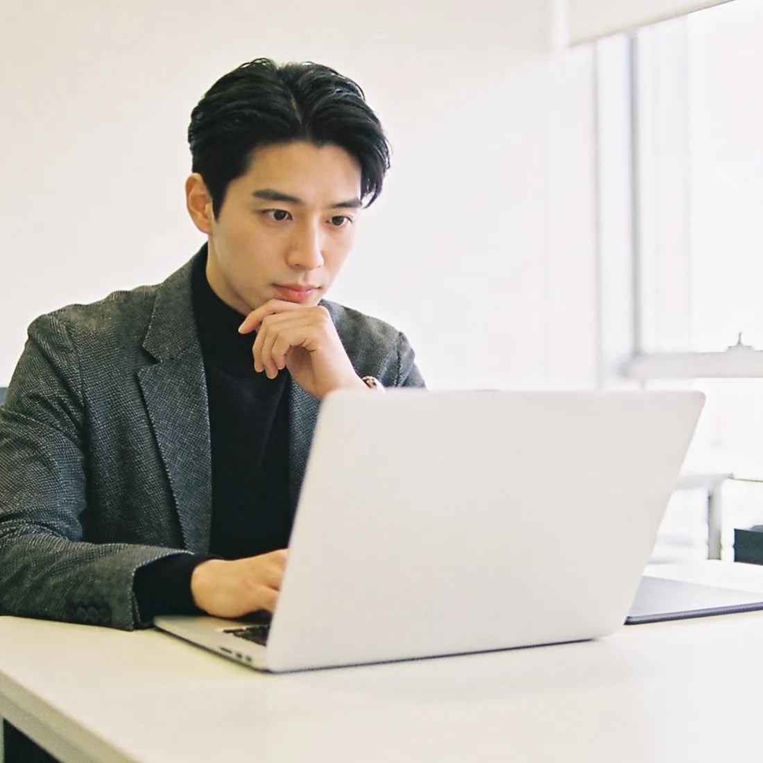 A strategist analysing competitor feeds on a laptop